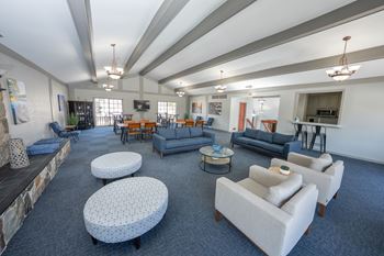 A spacious living room with a stone fireplace and a variety of seating options
